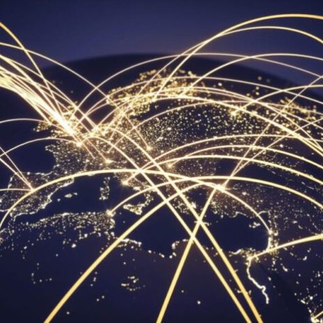 A NASA image of the world at night with abstract network lines, symbolising international recruitment and global connection.