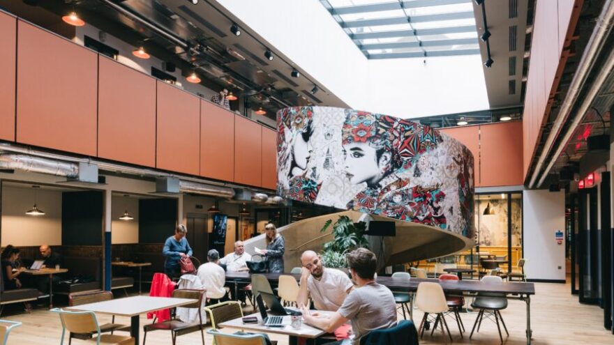 An interior shot of a WeWork building, with colour artwork, one of the best coworking spaces in the UK.